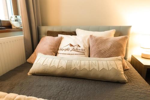 a bed with pillows on top of it at Alpejski Zieleniec in Duszniki Zdrój