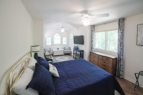 a bedroom with a blue bed and a tv at Cedar Hall in Bumpass