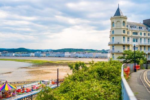 a large white building next to a beach at ANCHORAGE APARTMENT 5 - Two bed apartment close to the centre and the beach, located in Llandudno, North Wales in Llandudno