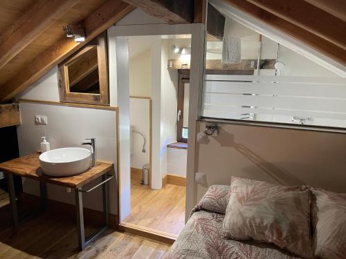 a bathroom with a sink on a table next to a bed at Los Chozos de la Braña in Brañosera