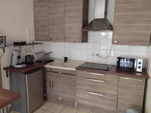 a kitchen with a sink and a microwave at appartement entier 2 chambres in Mantes-la-Ville