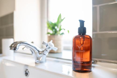 a bottle of soap sitting on a bathroom sink at The Buddle Inn in Ventnor