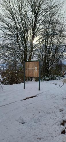 a sign in the snow in front of a tree at L'Écureuil - Terrasses de Malmedy in Malmedy
