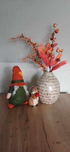 two stuffed animals sitting on a table next to a vase at L'Écureuil - Terrasses de Malmedy in Malmedy