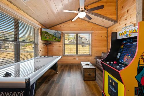 a room with a pool table and a video game at Modern 4 Bedroom Cabin in Timeless Resort Near Parkway and Dollywood with Game Room and Hot Tub in Sevierville