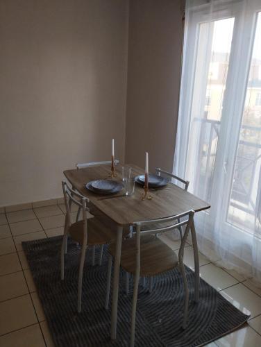 une table en bois avec deux bougies au-dessus dans l'établissement appartement entier 2 chambres, à Mantes-la-Ville