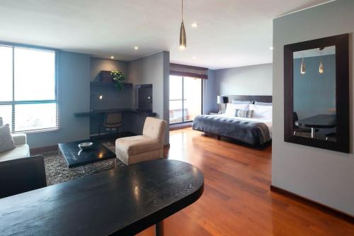 a bedroom with a bed and a living room with a table at Luxury Stay in Zona G King Bed 404 in Bogotá