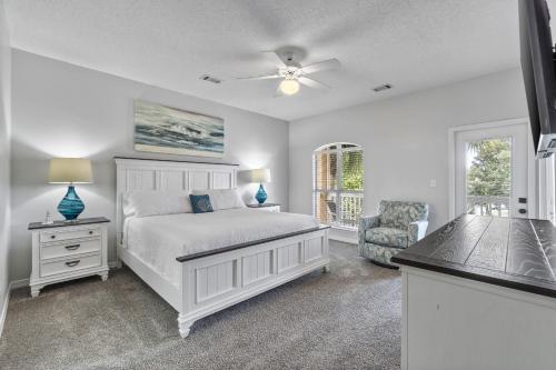 Un dormitorio con una cama y una silla y una ventana. en Luxury Beach House Steps from Pool and Short Walk to Private Beach Pavilion, en Destin