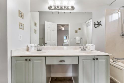 Baño blanco con 2 lavabos y espejo grande en Luxury Beach House Steps from Pool and Short Walk to Private Beach Pavilion, en Destin