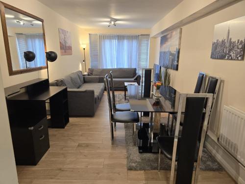 a living room with a couch and a table at Cranes apartments in Watford West Station