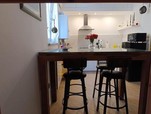 a kitchen with a bar with stools in it at La Dolce Vita, Vomero in Naples