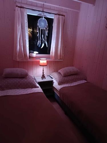 a room with two beds and a window with a skull hanging at Domki Rekreacyjne "Błękitne Wzgórze" in Żałe