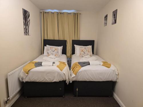 two beds sitting next to each other in a room at Cranes apartments in Watford West Station