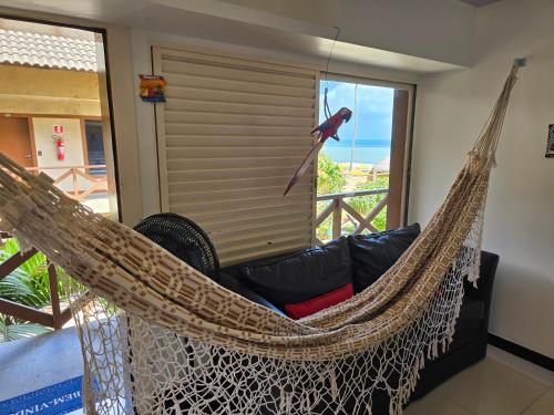 a hammock with a bird on it in a room at FRENTE MAR - Cumbuco - Eco Paradise in Cumbuco