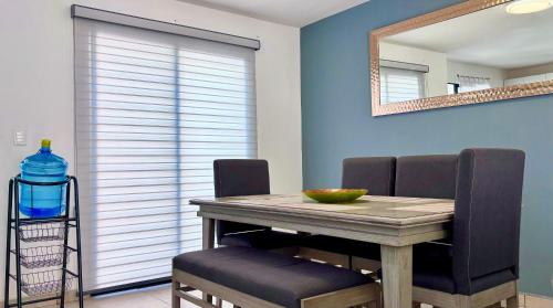a dining room table with two chairs and a mirror at EXCELENTE ALBERCA PRIVADA EN RESIDENCIAL PRIVADO, GYM, asador in Ciudad Valles