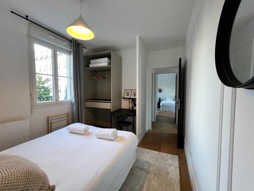 ein Schlafzimmer mit einem weißen Bett und einem Fenster in der Unterkunft Lifestyle Disneyland Paris 8 PAX in Serris