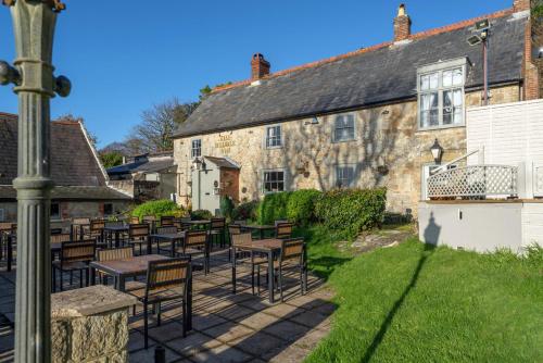 an outdoor patio with tables and chairs in front of a building at The Buddle Inn in Ventnor