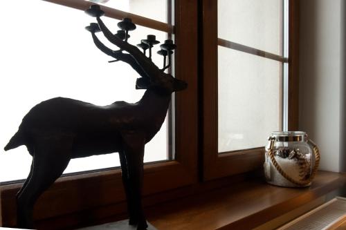 a statue of a deer sitting on a window sill at Alpejski Zieleniec in Duszniki Zdrój