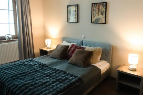 a bedroom with a bed with two lamps on two tables at Alpejski Zieleniec in Duszniki Zdrój