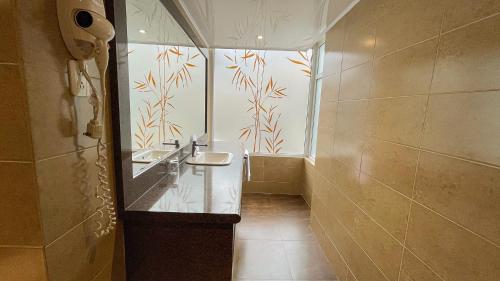 a bathroom with two sinks and a large window at Mercure Alameda Quito in Quito