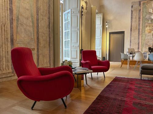 a living room with red chairs and a table at Hotel Palazzo Grillo in Genova