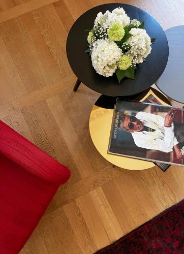a table with a bowl of flowers and a magazine at Hotel Palazzo Grillo in Genova