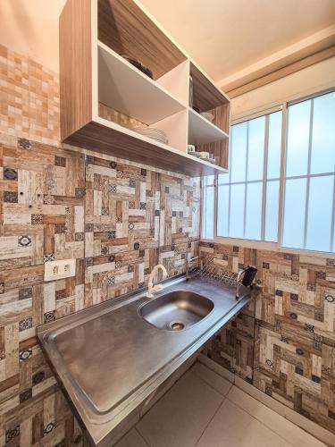 a kitchen with a stainless steel sink and tiles at Pousada Cheiro do Mar in Porto De Galinhas