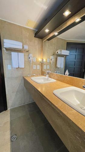 a bathroom with two sinks and a large mirror at Mercure Alameda Quito in Quito