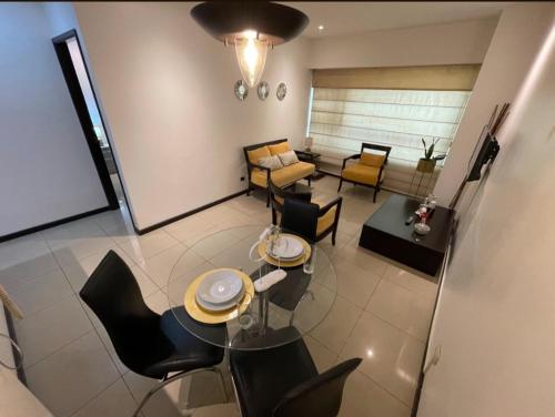 a living room with a table and chairs and a couch at Ecuabook torre sol 32 mall del Sol in Guayaquil