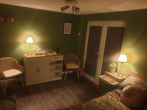 a bedroom with a bed and a desk and chairs at Farsley guest room seperate entrance with double bedroom and private shower room in Farsley