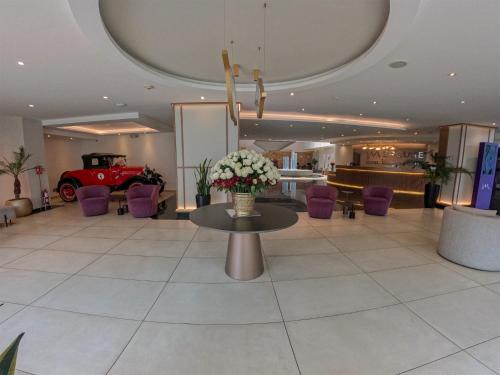 a lobby with a table with flowers and a red car at Mercure Alameda Quito in Quito