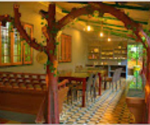 a restaurant with tables and chairs and a tree at Holy Village Homestay in Neriyamangalam