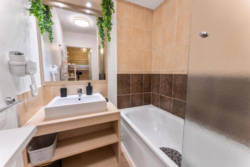 une salle de bain avec un lavabo et une baignoire dans l'établissement Résidence Les Terrasses Du Soleil D'or - Appartement calme à l'orée des pistes MAE-6594, aux Orres