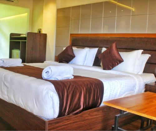 a hotel room with two beds and a table at Holy Village Homestay in Neriyamangalam