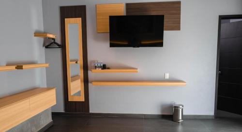 a room with wooden shelves and a television on a wall at Hotel Esmeralda in Atlixco