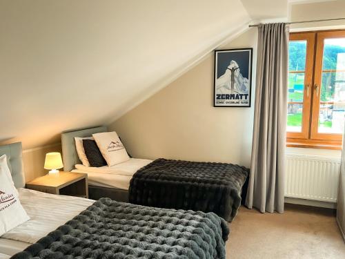 a hotel room with two beds and a window at Alpejski Zieleniec in Duszniki Zdrój
