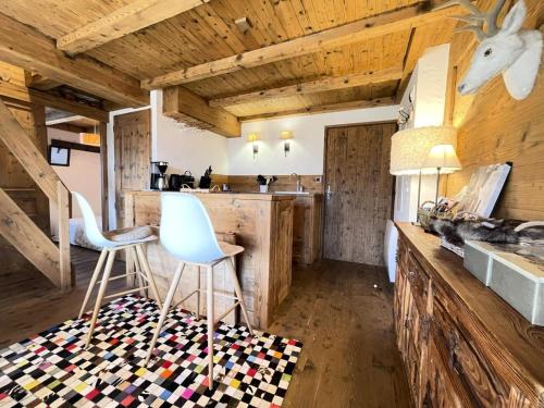une chambre avec deux chaises et une cuisine avec des murs en bois dans l'établissement Résidence Les Epines Blanches - Appartement de charme proche village, à côté des pistes MAE-7234, à Crest-Voland