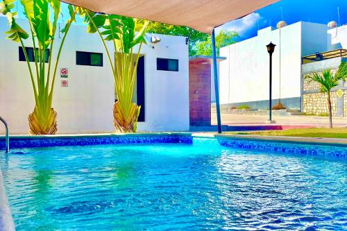 a swimming pool with blue water in front of a building at EXCELENTE ALBERCA PRIVADA EN RESIDENCIAL PRIVADO, GYM, asador in Ciudad Valles