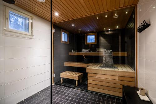 a bathroom with a shower with a bench in it at Villa Nightsky -private location, sauna and jacuzzi in Rovaniemi