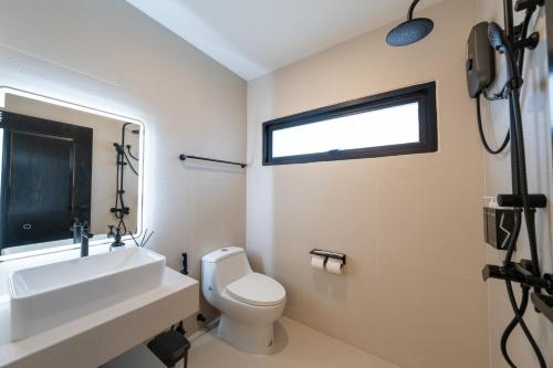 a bathroom with a toilet and a sink and a window at House 158 Patong Pool Villa 4BR Near Beach in Patong Beach