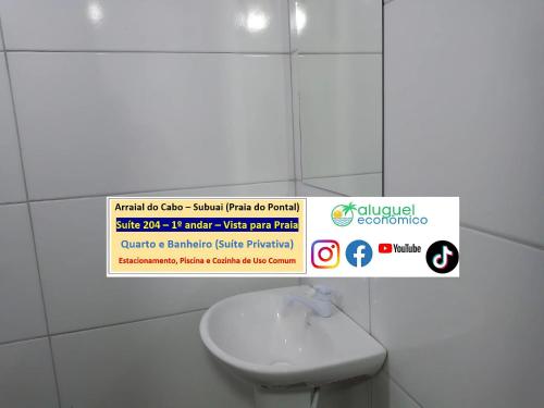 a sign in a bathroom with a toilet and a sink at Arraial do Cabo – Subuai Village - Aluguel Econômico in Arraial do Cabo