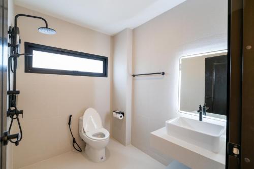 a bathroom with a toilet and a sink and a mirror at House 158 Patong Pool Villa 4BR Near Beach in Patong Beach