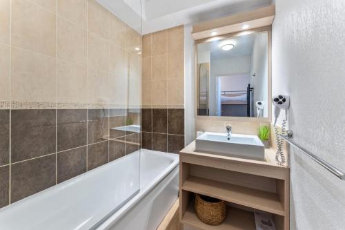 une salle de bain avec un lavabo, une baignoire et un miroir dans l'établissement Résidence Les Terrasses Du Soleil D'or - Studio 4 couchages avec vue pistes MAE-0481, aux Orres