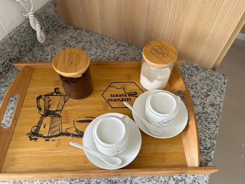 a wooden tray with two cups and saucers on it at Samana Complexes Los Robles VII in Los Paredones