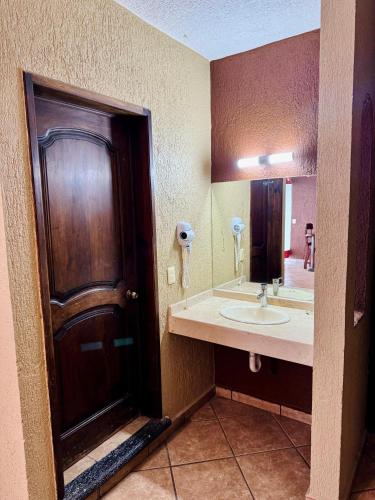 a bathroom with a brown door and a sink at Hotel Cabañas Santa Cruz in Oaxtepec
