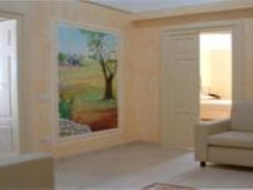 a living room with a painting on the wall and a chair at B&B Frammenti D'Itria in Ceglie Messapica
