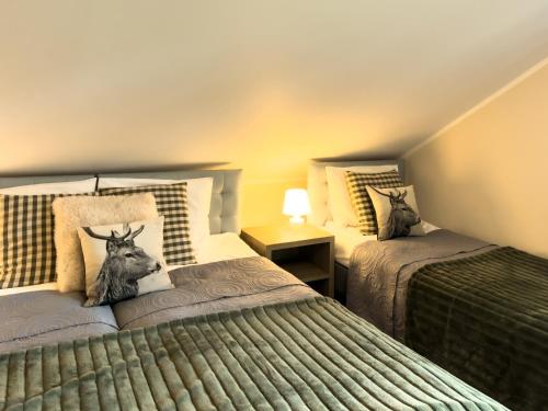a bedroom with two beds with a picture of a deer on the pillow at Alpejski Zieleniec in Duszniki Zdrój