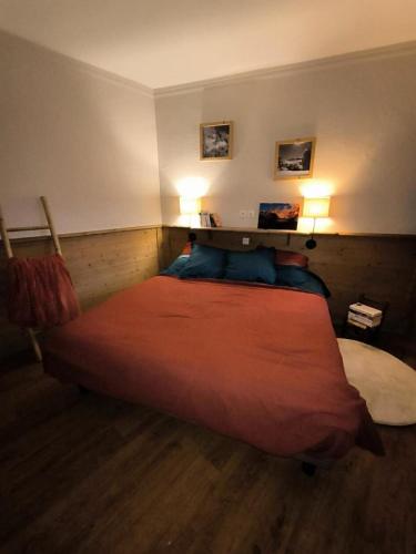 - une chambre avec un grand lit et deux lumières sur le mur dans l'établissement Chalet Alaska - Appartement familial tout confort avec piscine MAE-9531, à Val Thorens