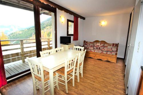 un salon avec une table et des chaises et un balcon dans l'établissement Résidence Les Balcons De La Vanoise - LES BALCONS DE LA VANOISE-BV102 MAE-9031, à Villarodin-Bourget