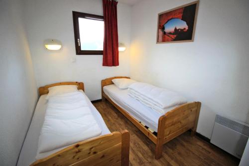 deux lits dans une petite pièce avec une fenêtre dans l'établissement Résidence Les Balcons De La Vanoise - LES BALCONS DE LA VANOISE-BV102 MAE-9031, à Villarodin-Bourget